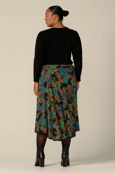 An asymmetric, midi skirt in floral, 'Secret Garden' print jersey, by Australian and New Zealand women's clothing brand, L&F. The Germaine Skirt is shown here for fuller figure women, in a size 18 and is worn with a long sleeve, V-neck top in black jersey. Shop this jersey skirt in sizes 8 to 24.