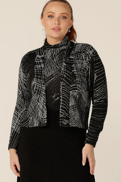 A blend of jacket and cardigan, this textured knit 'jacardi' is a good way to layer up for winter. Worn by a size 12 woman, this knit jacket is worn with a matching polo neck top to create a modern twinset for winter workwear layering.