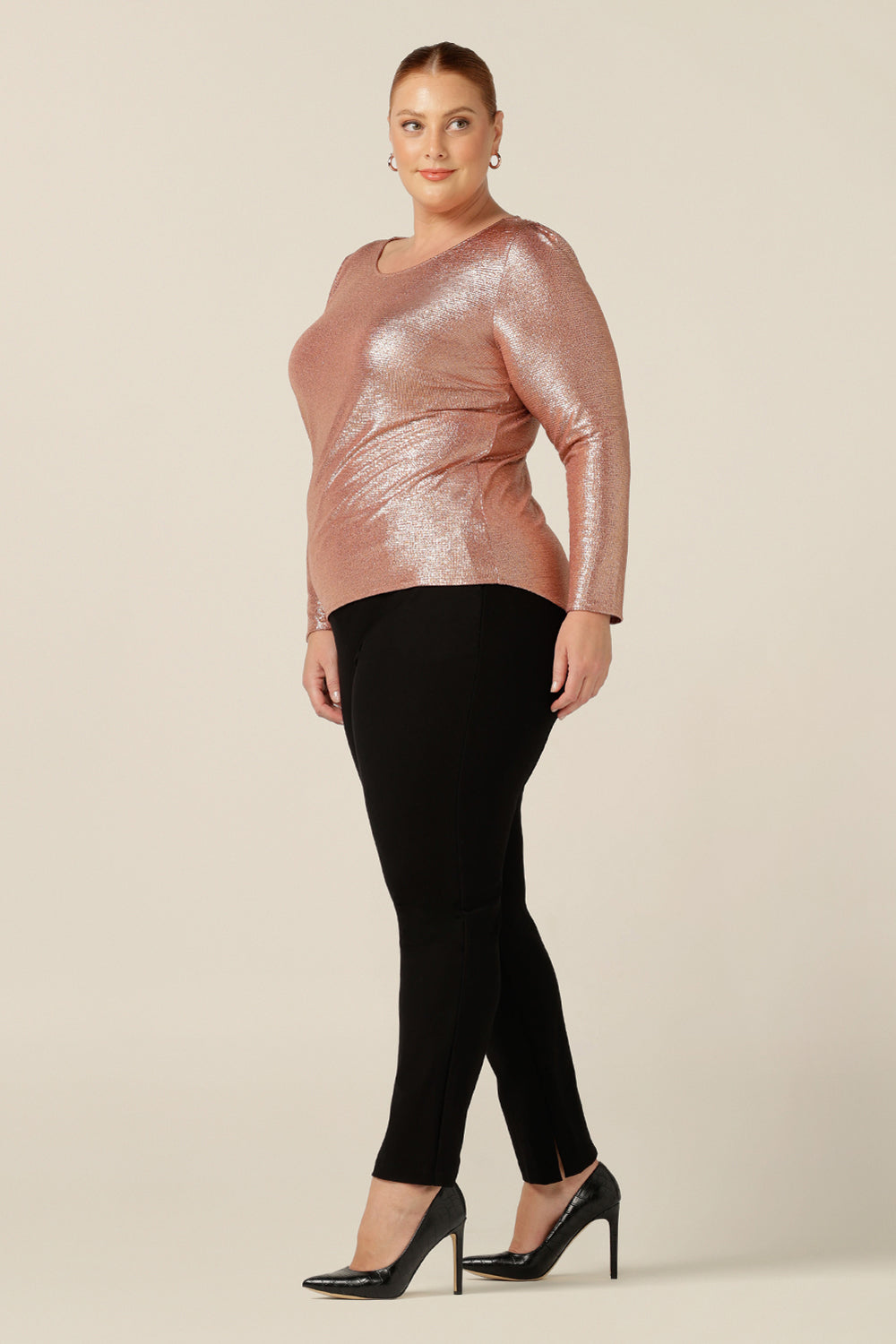 A pretty sparkly top for evening and occasionwear, the Jody Top in shimmering pink jersey has a high scoop neck and long sleeves. This women's top is shown in a size 18 and worn with slim leg black evening pants. Made in Australia by Australian and New Zealand women's clothing brand, L&F, this evening top is available for petite to plus size women in sizes 8 to 24.