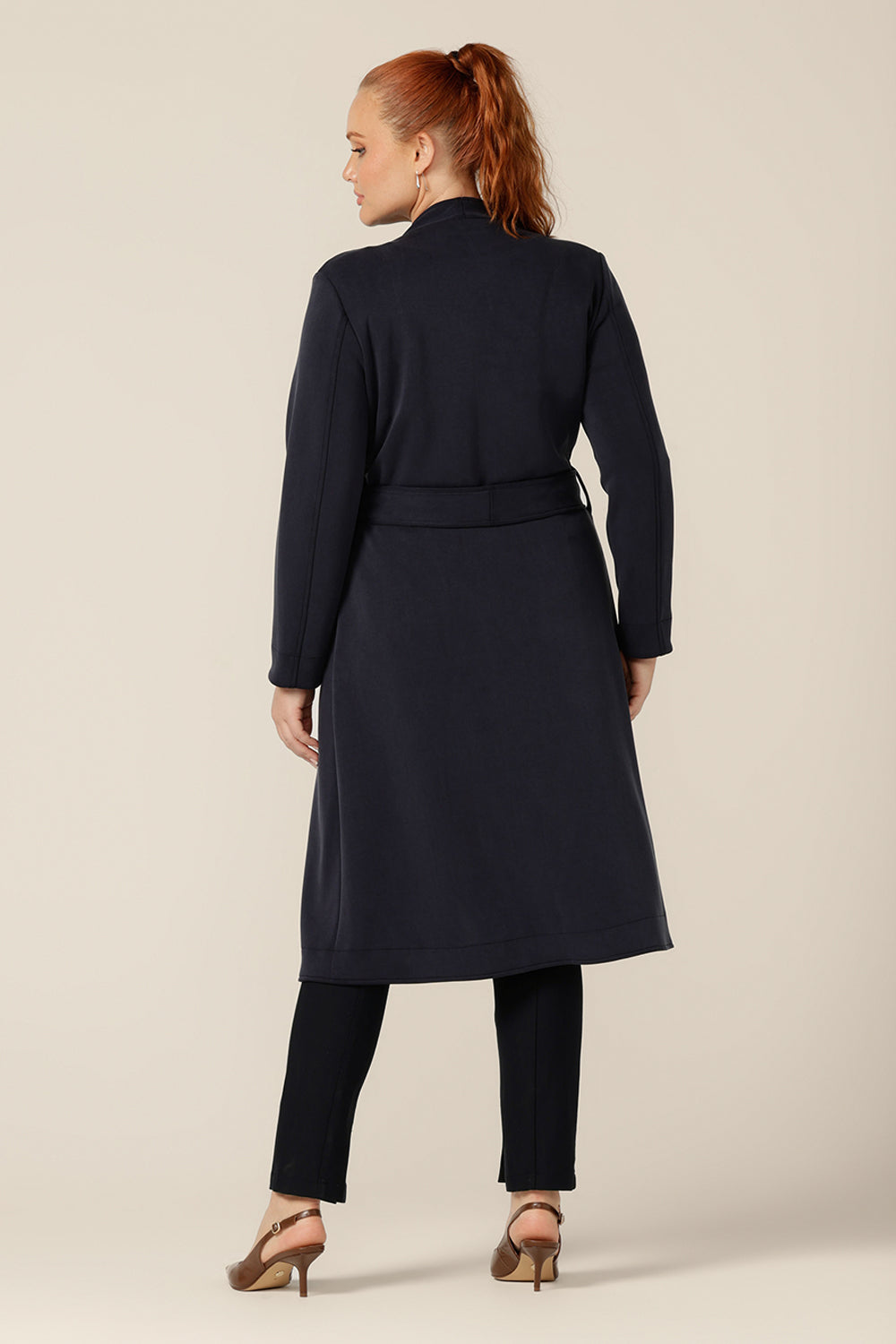 Back view of the best coat for Australia and New Zealand winters, the Marant Trenchcoat in Bluestone is made from winter-weight modal fabric for luxurious comfort. A collarless, open fronted coat with tie belt and patch pockets, this classic women's jacket makes for an elegant yet warm transeasonal navy coat.