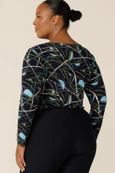 Back view of a size 18, plus size woman wearing a long sleeve, boat neck top by Australian and New Zealand women's clothing brand, L&F. Featuring a blue, green and white print on a navy jersey base, this top is a great top for work and corporate wear.