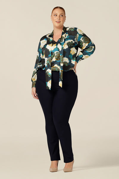 A luxe pull-on shirt in abstract floral print, the Matisse Shirt in Pom Pom has a V-neckline with pussy bow neck ties and long, bishop sleeves that blouson over fitted cuffs. This shirt is worn tucked in to slim leg navy pants as an elegant workwear top.