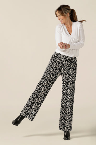 A size 10 woman wears wide leg, pull pants with a deep waistband in black and white jersey. Worn with a long sleeve white bamboo jersey top, these easy care pants are great for work and corporate wear.