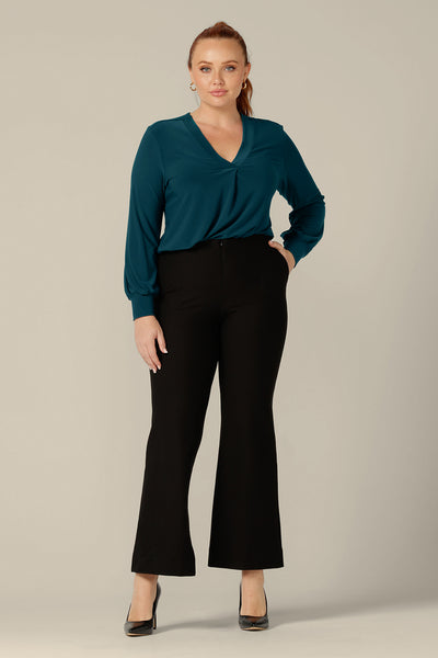 Long sleeve, V-neck top in dark teal jersey, size 12, worn with flared, leg black work pants, both by Australian and New Zealand women's clothing company, L&F.