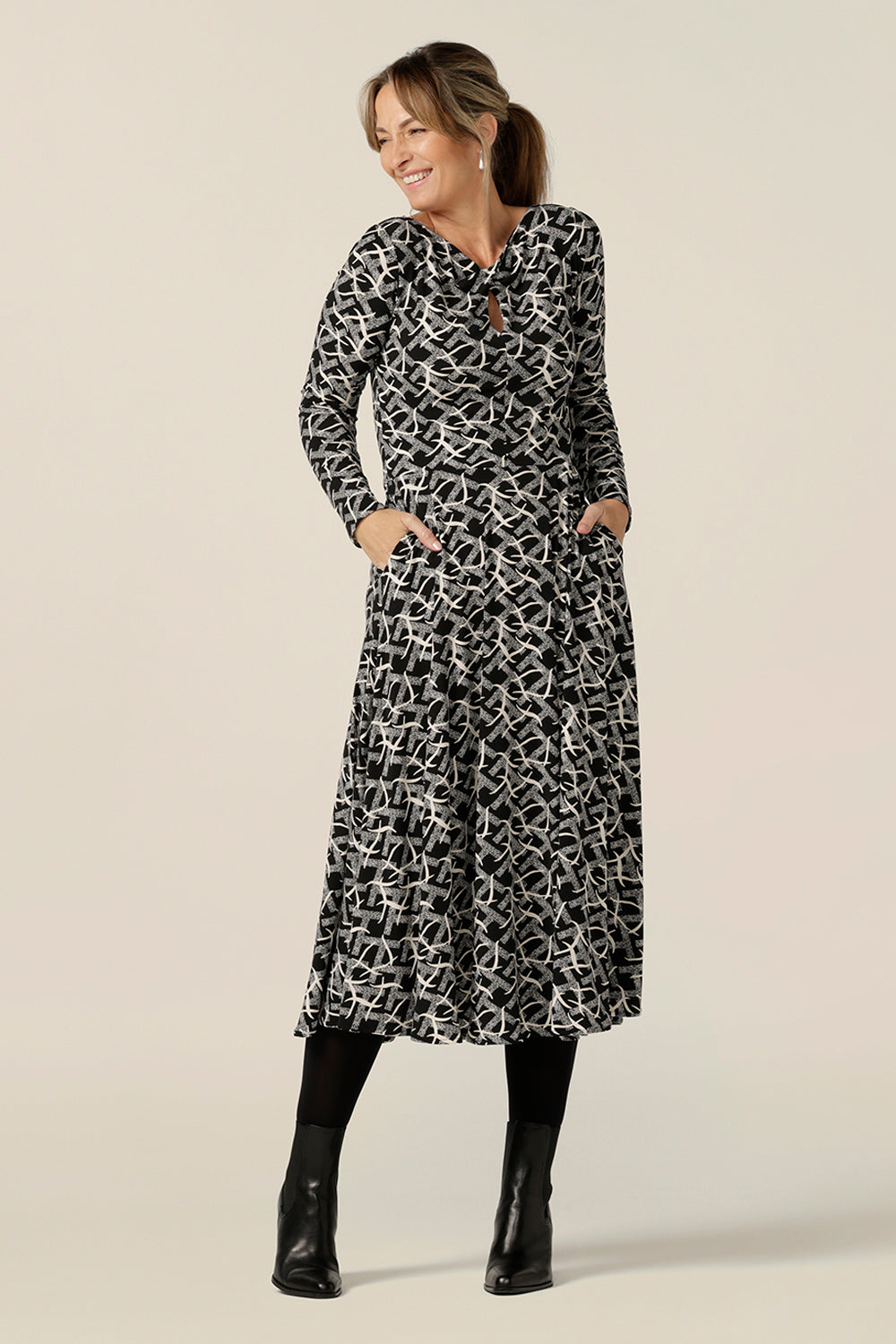 A size 10 woman wears a midi length, long sleeve dress with twisted keyhole detail. Made by Australian and New Zealand women's fashion brand, L&F in an inclusive size range of sizes 8 to 24. Shop this dress for work