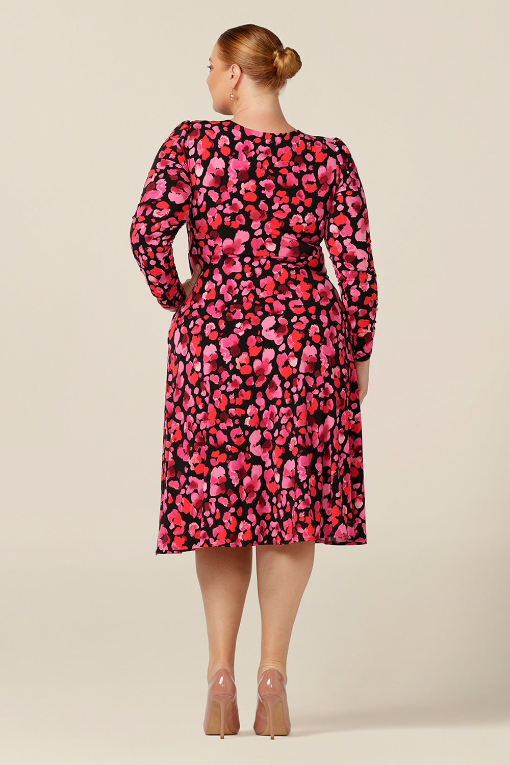 back view of a printed jersey dress in size 18, with red poppy floral pattern. This empire line dress has a V neck, long sleeves and knee length skirt. 
