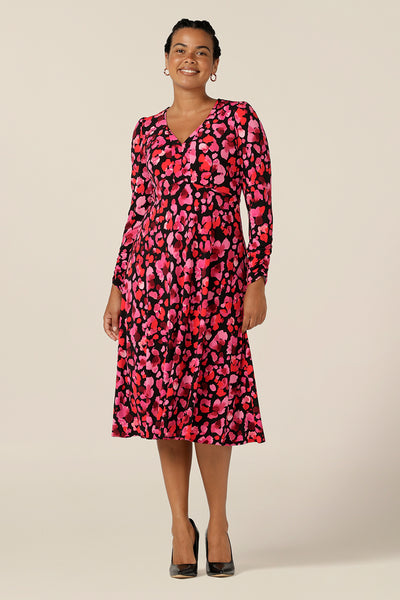 a size 12 woman wears an empire line jersey dress with a V neckline, knee length skirt and long sleeves. The dress is Australian made by Queensland-based, Leina and Fleur - making clothes for the women of Australia and New Zealand