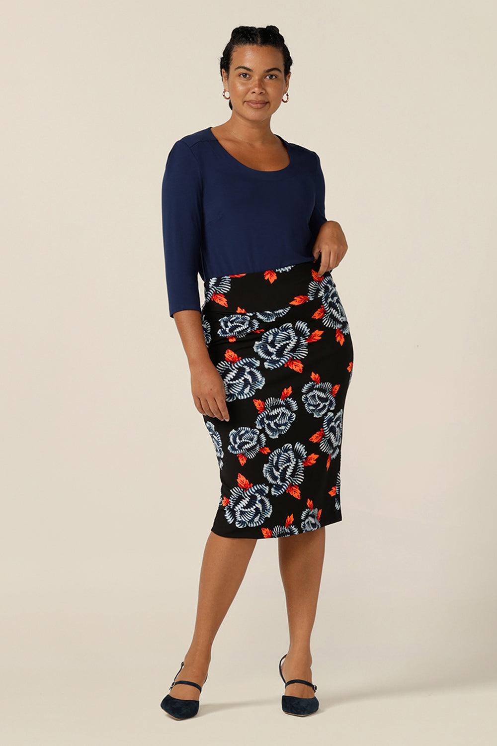 A great skirt for work and corporate wear, the Andi Skirt in Ikebana is a tube skirt in stretch jersey fabric. Australian-made by Australia and New Zealand women's clothing brand, L&F, this black skirt has a blue and orange floral pattern. This modern print skirt is worn with a 3/4 sleeve, round neck top in navy blue bamboo jersey. Shop this skirt in an inclusive size range of 8-24.