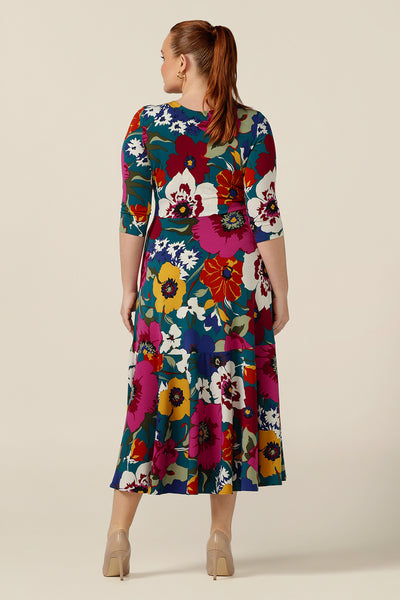 Back view of a size 12, curvy woman wearing a reversible wrap dress in printed jersey. Made in Australia by Australian and New Zealand women's clothing brand, L&F this 3/4 sleeve jersey dress is worn with a V-neckline to the front and high back but reverse it and it becomes a boat neck dress! A dress for work wear, casual or occasion wear, shop your next event dress now in sizes 8-24.