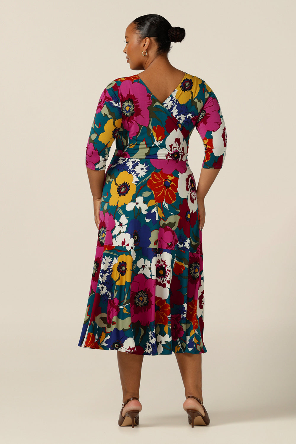 Back view of a size 18, plus size woman wearing a reversible wrap dress in printed jersey. Made in Australia by Australian and New Zealand fashion brand, L&F this 3/4 sleeve jersey dress is worn with a boat neckline and low V back but reverse it and it becomes a wrap dress! A dress for workwear, casual or occasion wear, shop your next going-out dress now in sizes 8-24.