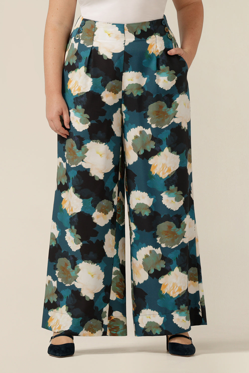a size 12  woman wears high-waisted printed wide-leg trousers. Made in Australia from sustainable natural fibres, these eco-conscious pants are part of women's clothing brand, elarroyoenterprises's focus on sustainable fashion. 