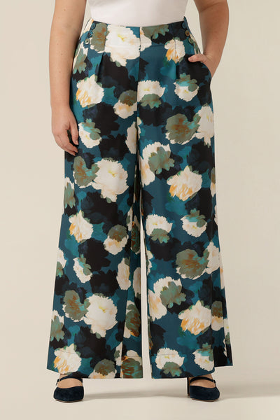 a size 12  woman wears high-waisted printed wide-leg trousers. Made in Australia from sustainable natural fibres, these eco-conscious pants are part of women's clothing brand, elarroyoenterprises's focus on sustainable fashion. 