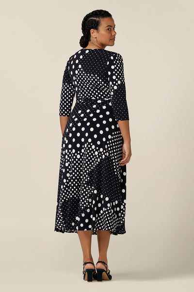 Back view of a jersey wrap dress with navy and white spot prin.  A good workwear dress, it features 3/4 sleeves and a full, midi length skirt. Made  in Australia, this wrap dress is part of women's clothing label, L&F's range of work wear fashion for the women of Australia and New Zealand.