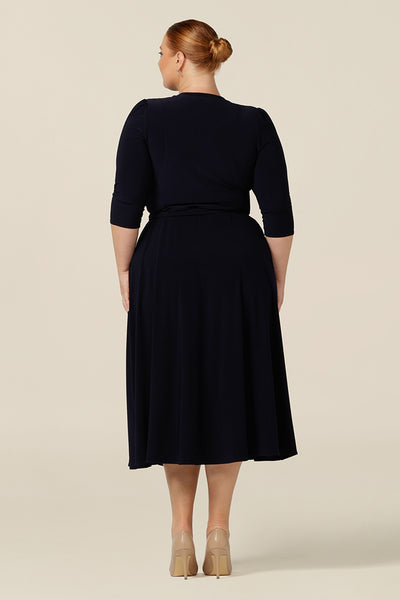 Back view of an Australian-made, navy jersey, wrap dress with 3/4 sleeves. A great workwear dress,  this wrap dress is styled with heels as an elegant corporate dress.