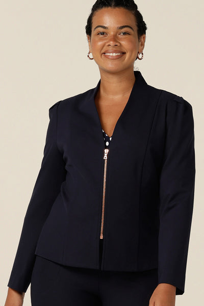 Shop this modern corporate women's jacket online. A collarless, navy blue, tailored jacket with full length sleeves, a rose gold zip fastening is made in Australia by women's clothing label, elarroyoenterprises.