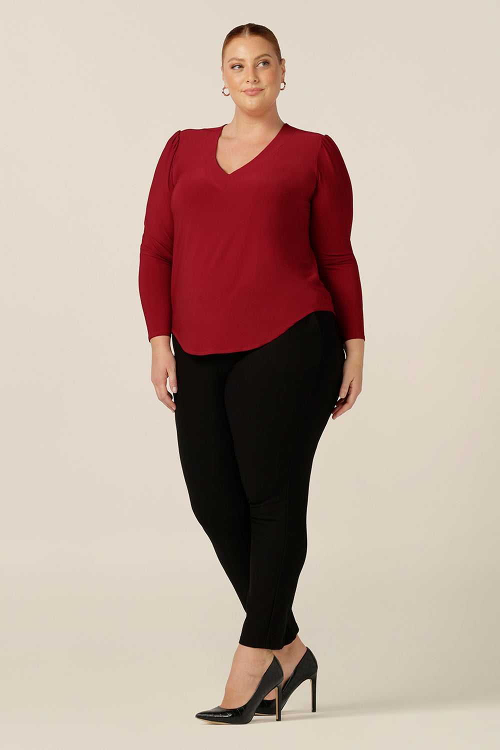 The perfect top for workwear and casual style, the Glyn Top in Flame red jersey features a V neck, shirttail hemline and long sleeves. Worn with slim leg work pants, this is a good top for corporate and event dressing. 