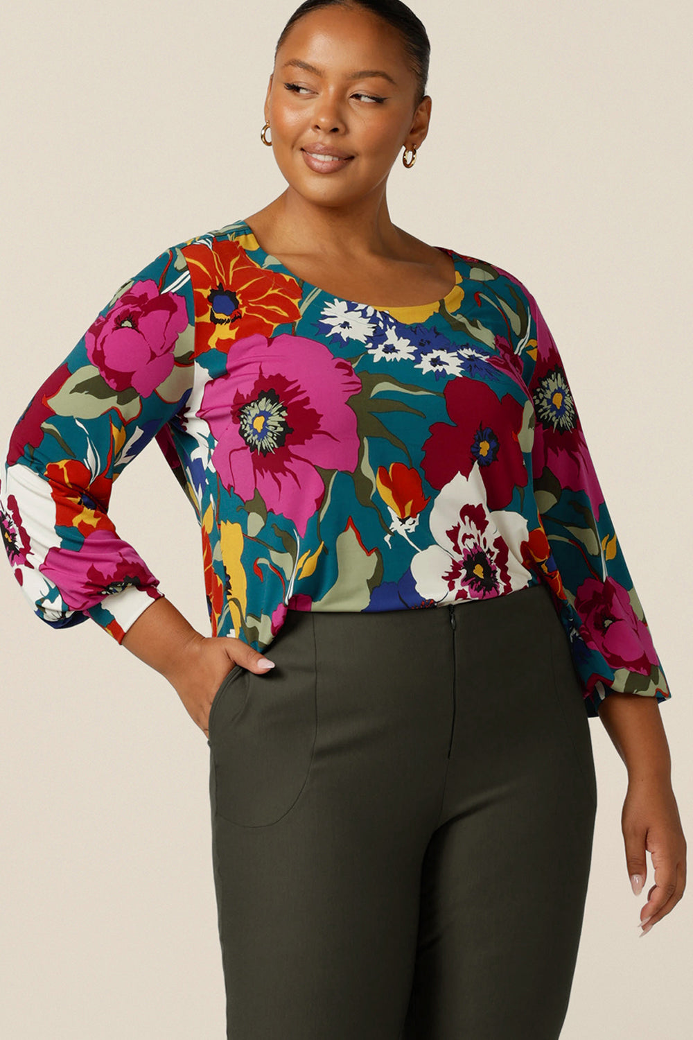 A fuller figure woman wears a tailored jersey top with long bishop sleeves, scoop neckline and shirttail hemline. Australian made, this work wear top for petite to plus size women is available to shop online at L&F Australia.