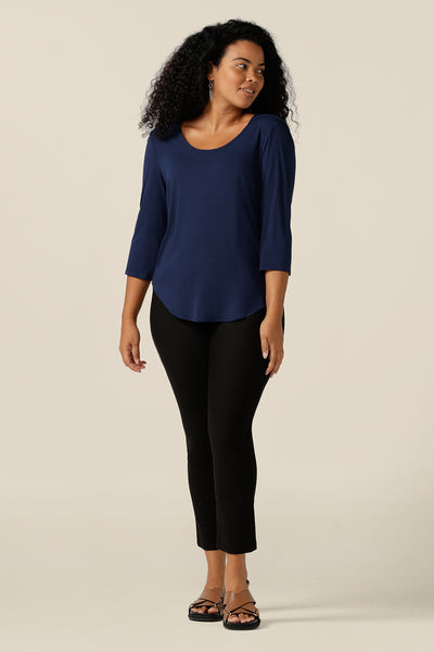 a size 12, curvy woman wears a french navy bamboo jersey top with a round neckline and 3/4 sleeves. Made in Australia in sustainable bamboo jersey, this casual women's top is lightweight, breathable and comfortable. the top is worn with cropped-length black pants.