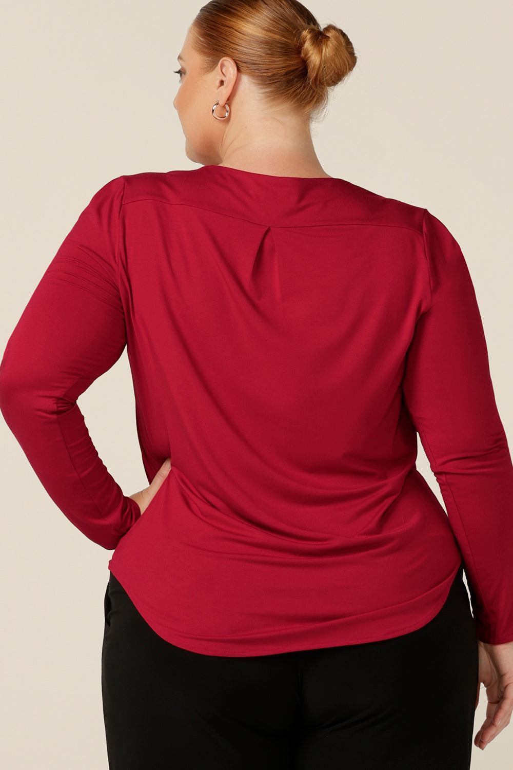 Back view of a fuller figure, size 18 woman wearing a red bamboo jersey top with long sleeves and a round neckline. Made in Australia, this top works for smart-casual workwear and off-duty style.