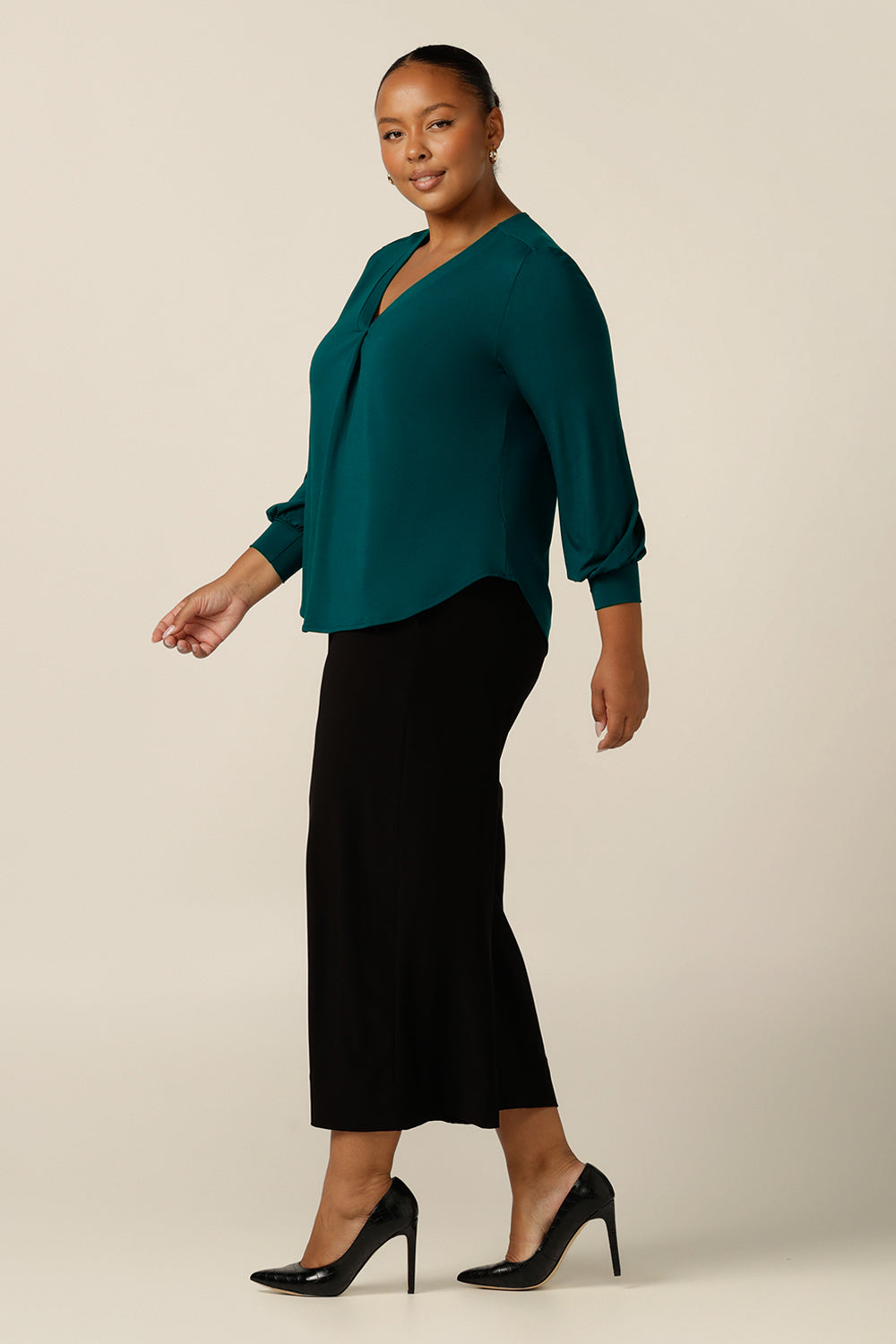 A size 18, plus size woman wears a long sleeve, V-neck top in bamboo jersey. Made in Australia, by Australian and New Zealand women's clothing company L&F,  shop this workwear top in petite to plus sizes.