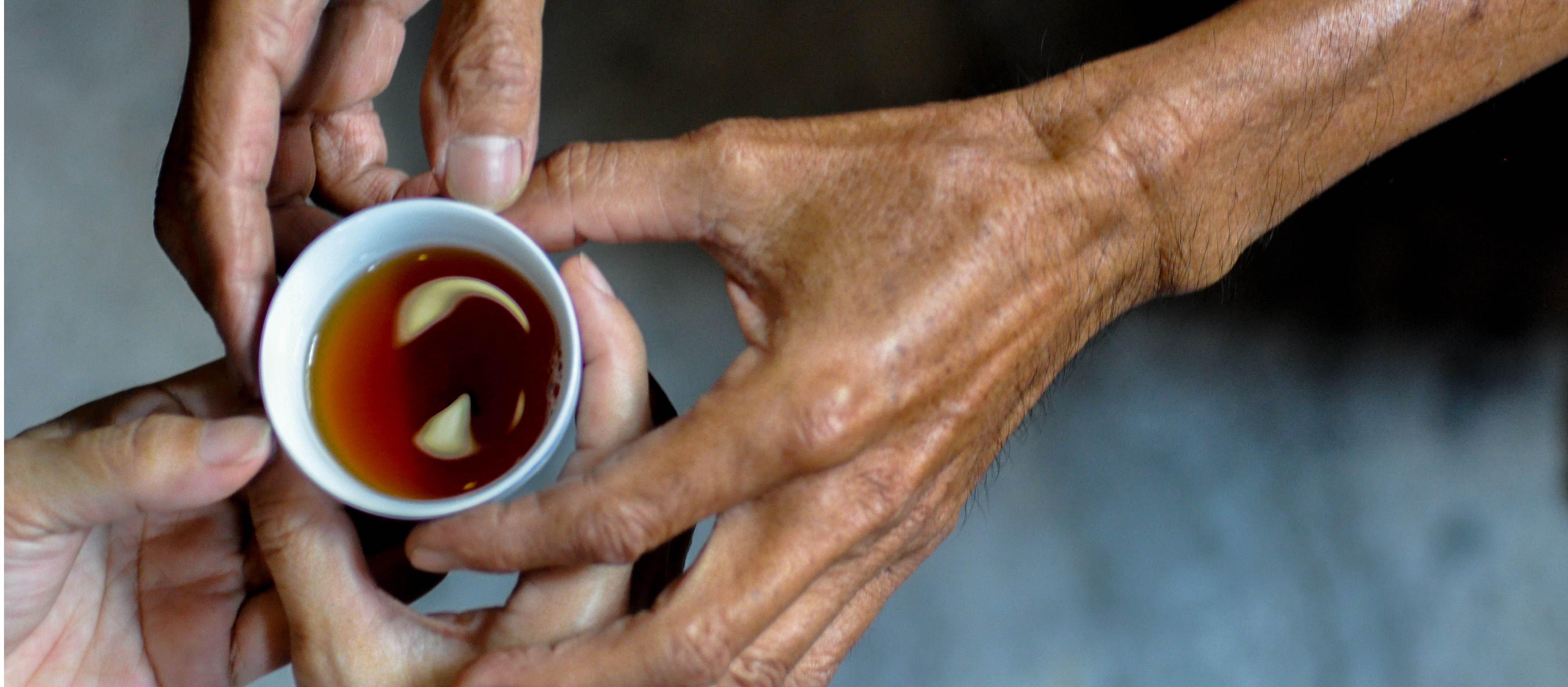 hand over a cup of ripe puerh tea to others