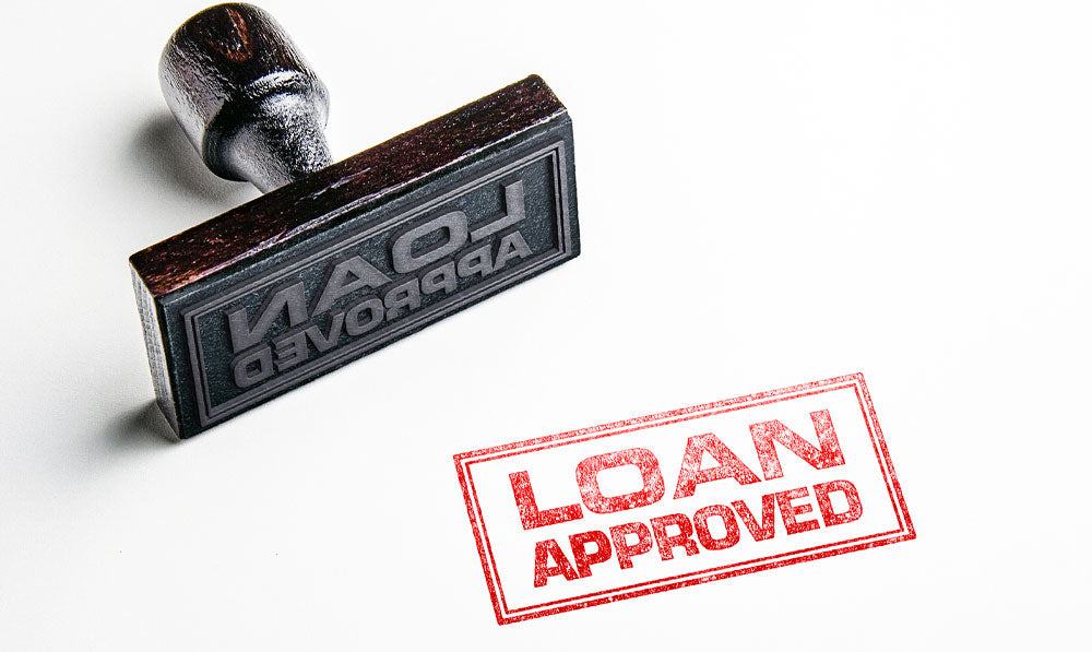Rubber Stamp with Loan Approved on white sheet