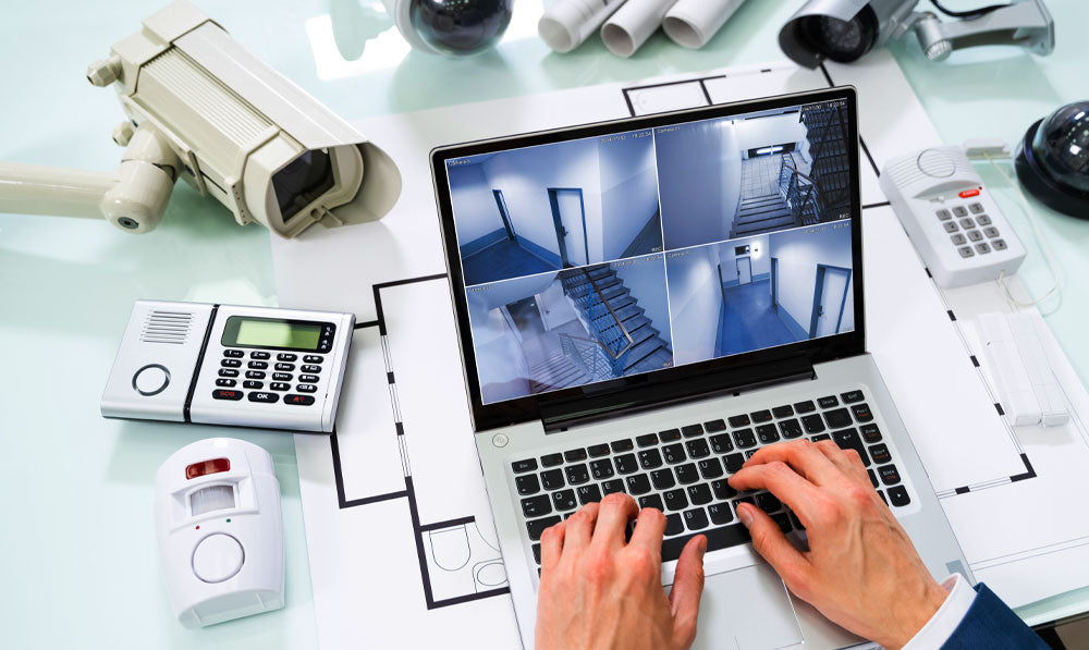 Man monitoring security systems on laptop on office table