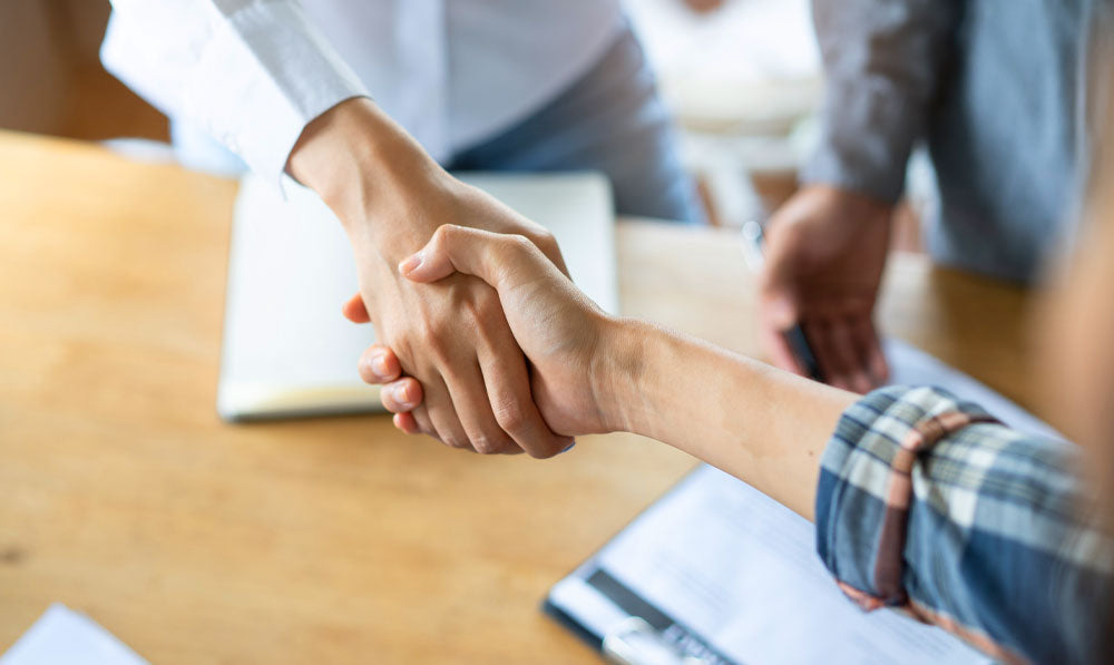 Two people shaking hands at a  business meeting