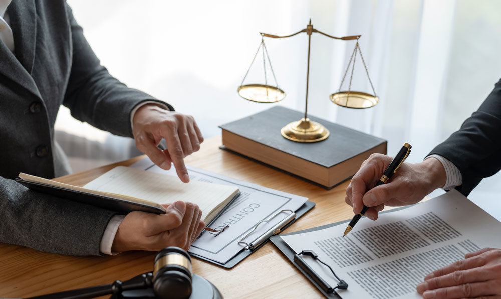 Lawyers and attorneys reviewing legislation with gavel and scales nearby