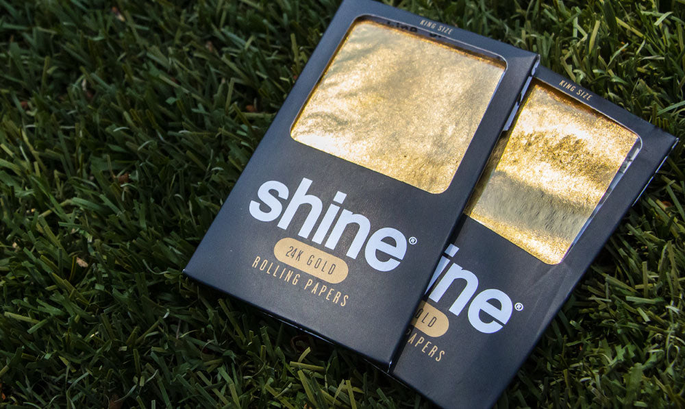 Shine 24k Gold Rolling Paper tumbado sobre el césped