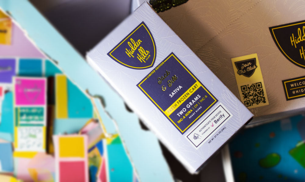 Hidden Hills Heady Blend Cartridges resting atop packaging with wall art nearby