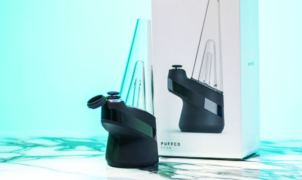 Puffco New Peak standing on marble surface under teal studio lighting