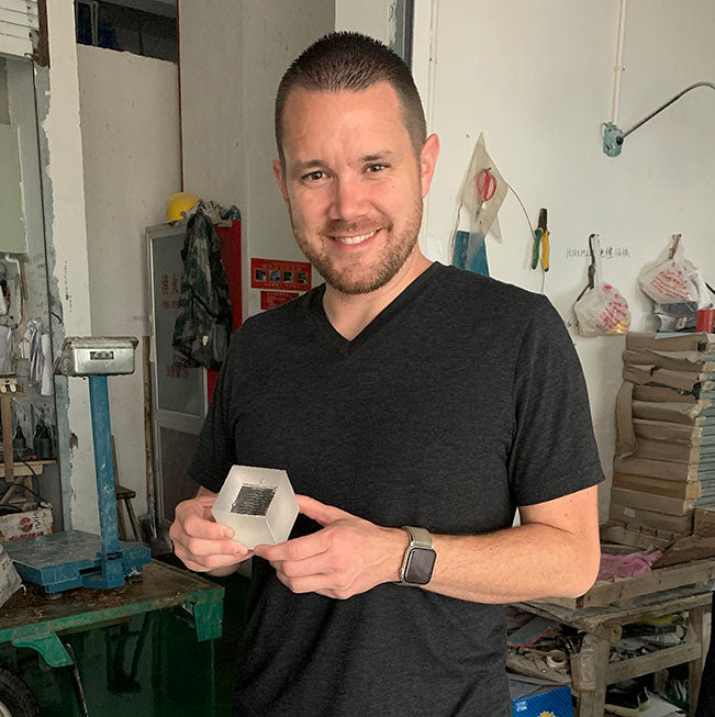 Holding an unpolished crystal in a factory where the glass is cut.