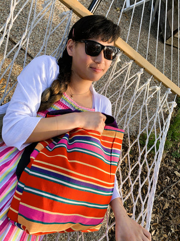 woman on hammock with striped tote bag