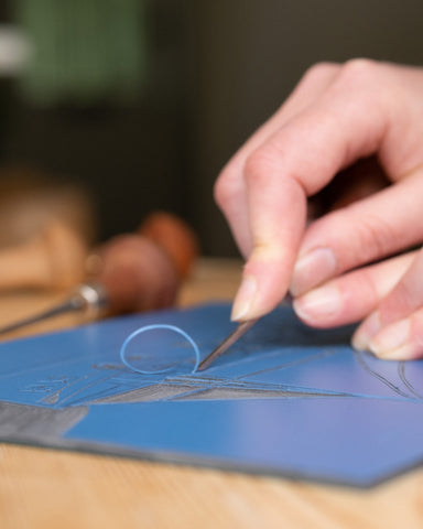 Carving the design using lino cut tools that are like very fine chisels