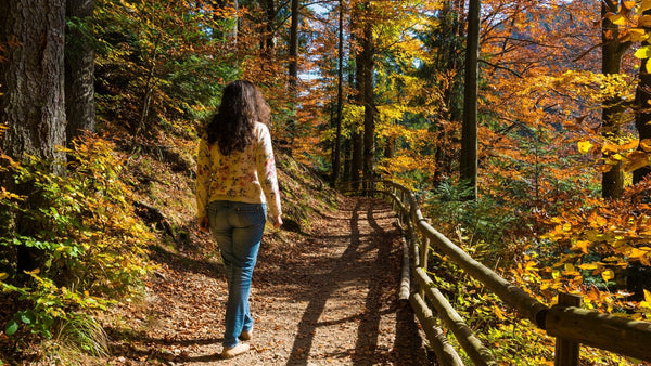 Woman walking on a trail in the woods. 