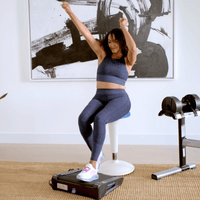 WOman in workout clothes on miniTREAD celebrating and thriving through seated movement