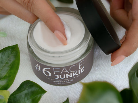 Product image of Face Junkie's #6 Pro Collagen Night Cream open with a finger scooping a lump of white cream out of the pot.