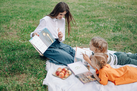 Mother reading to her children in a park