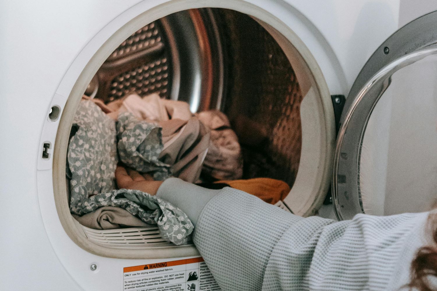Anonymous woman loading clothes in washing machine