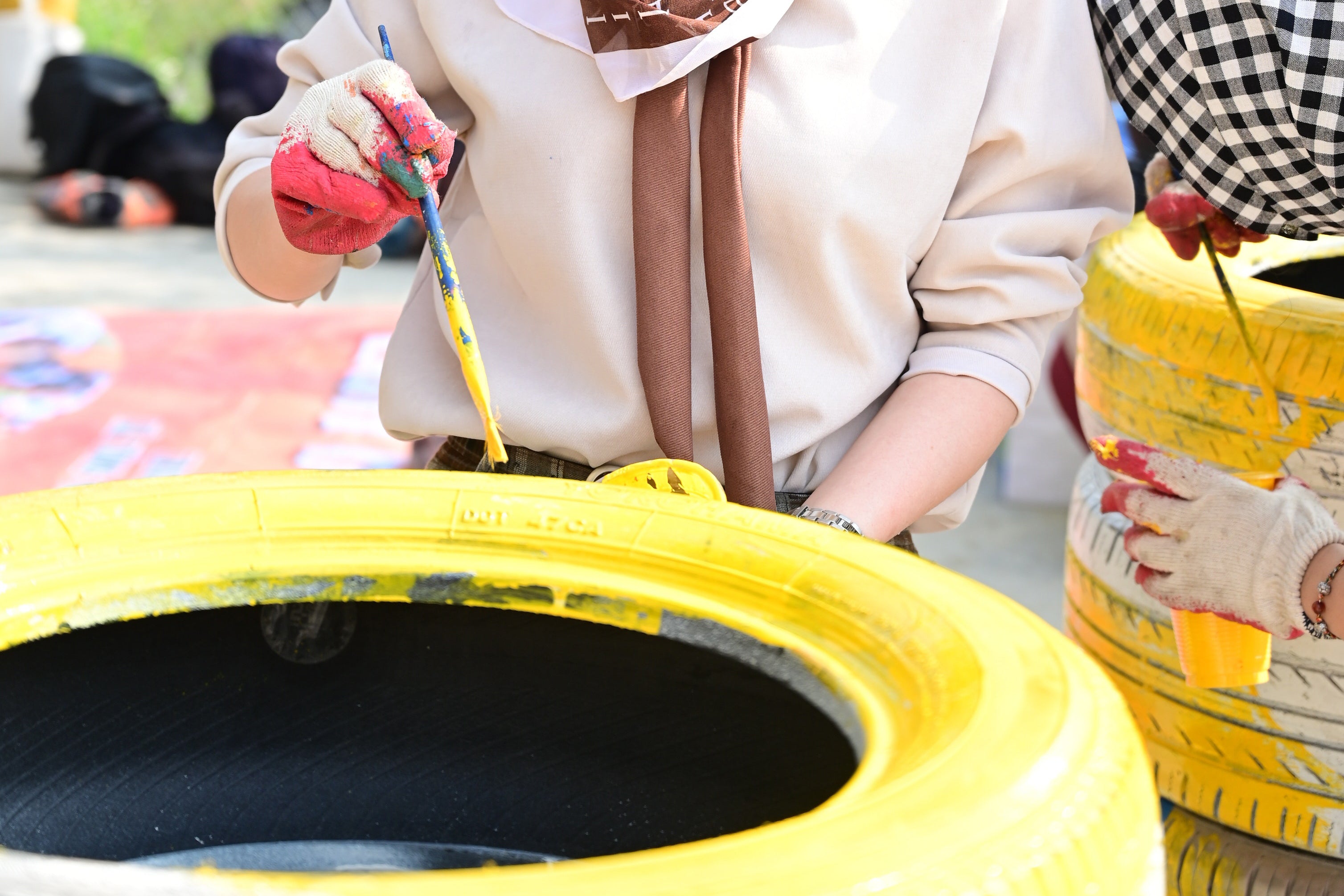 Woman Upcycling by Painting a Tyre