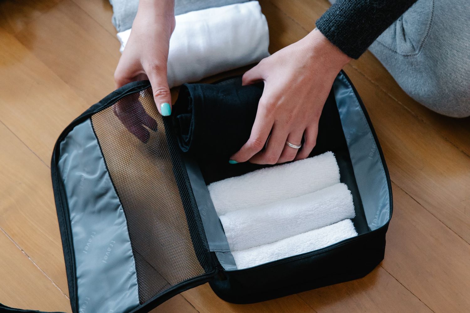 Woman Putting Rolled Towels on a Pouch