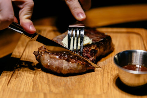Memotong steak dengan pisau dan garpu