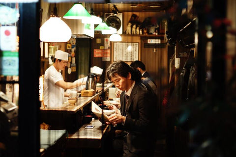 seorang pria sedang duduk di salah satu restoran jepang