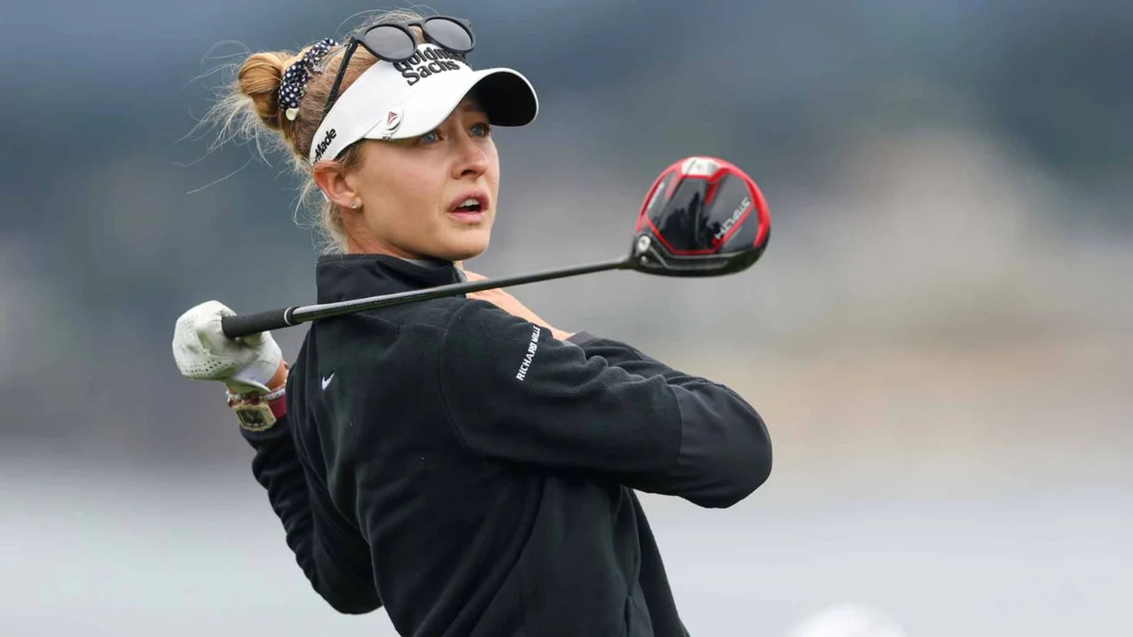 White woman golfer | sunglasses | black golf sweater