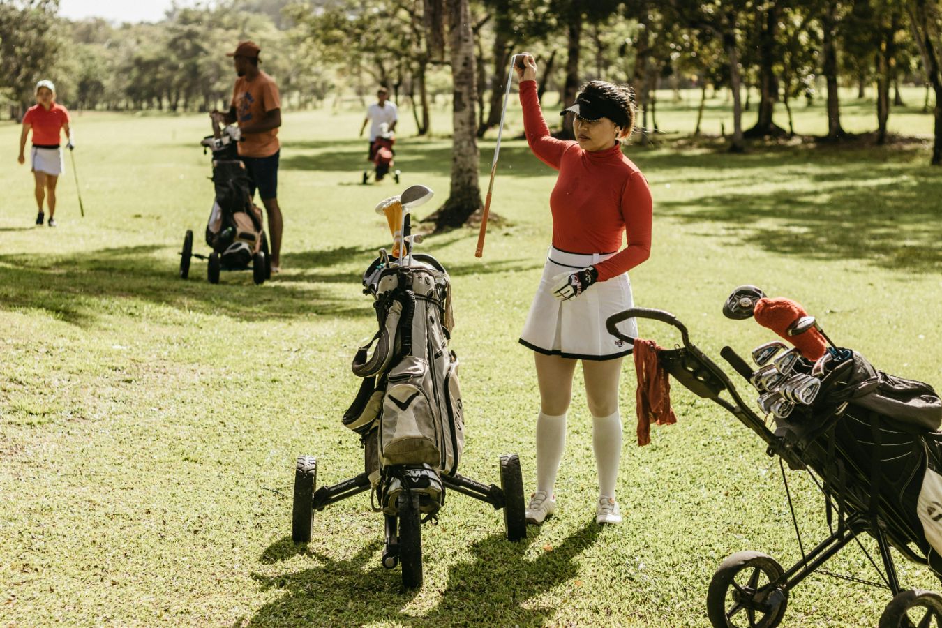 Woman golfer wearing golf skort and leggings | white visor