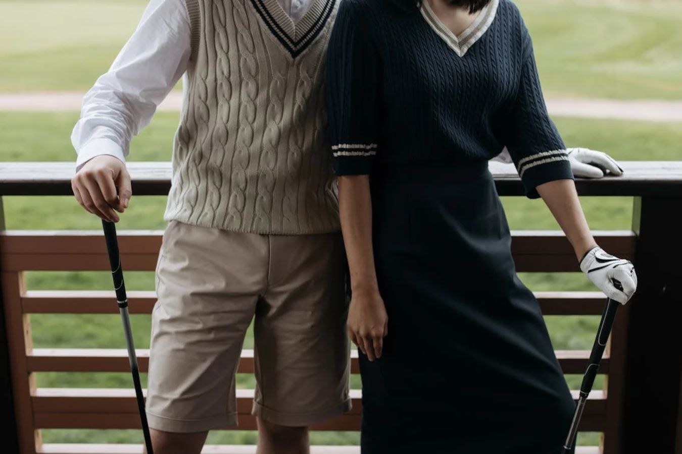 Elegantly-dressed male and female golfers | sweater vests | golf clubs