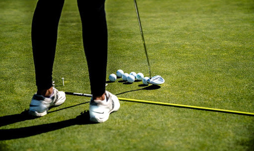 Woman's leggings | white sport shoes | golf practice | golf balls | golf putt