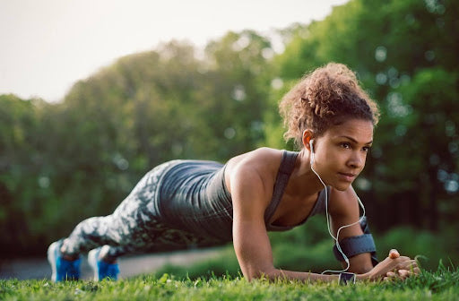 Woman wearing wired earphones in plank position