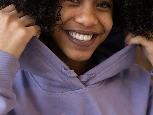 Black woman smiling | purple hoodie